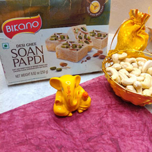 Bikano Soan Papdi with bright yello ganpati idol and cashews